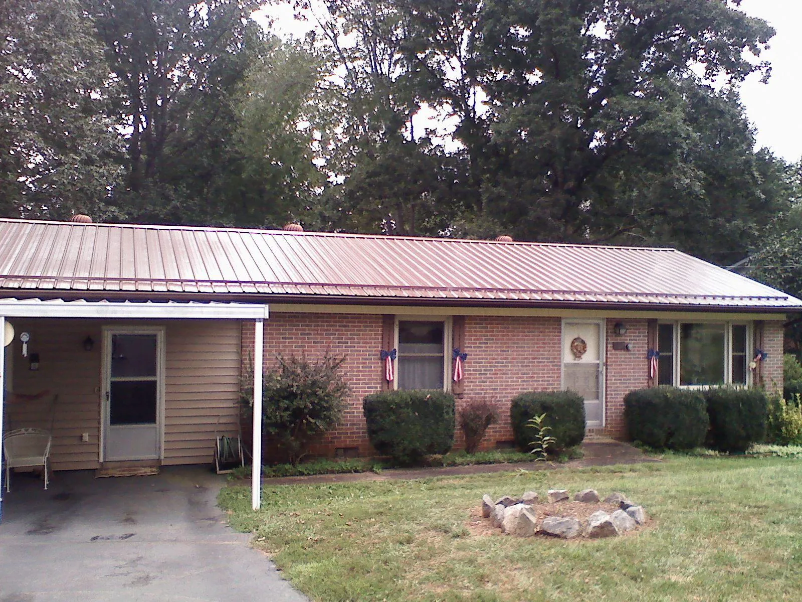 Bronze metal roof and carport on a brick ranch home — Roof Repair work by our crew in Redding